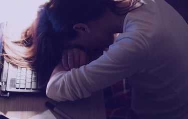 pessoa cansada por nao dormir bem e esta com a cabeça apoida sobre a escrivaninha