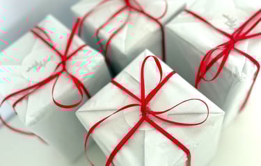 a bunch of white boxes with red ribbon tied to them