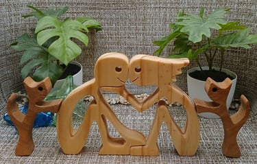 a wood figurine of a loving couple and their two pets