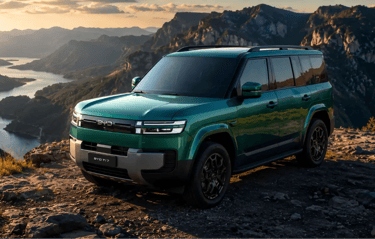 BYD Ti7 verde com visual robusto em estrada montanhosa ao pôr do sol