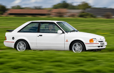 Ford Escort XR3i em movimento destaca desempenho e visual clássico esportivo