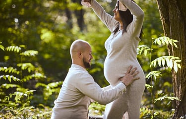 Mężczyzna trzyma brzuch kobiety w ciąży na tle egzotycznego krajobrazu