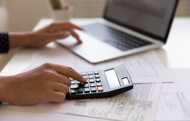 Someone in Front of Laptop Using Calculator