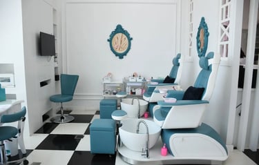 Modern luxury nail salon interior with blue pedicure chairs and foot baths on a black and white chec
