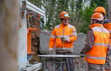 a group of men in orange safety vests and safety vests
