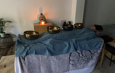 a person laying down receiving sound theraphy session with bowls