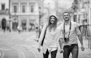 Happy, smiling, young couple, hand-in-hand, walking in a city street