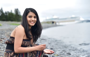 Dr. Rio Kashyap in a dress sitting on a beach
