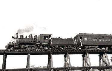 a train on a bridge over a river