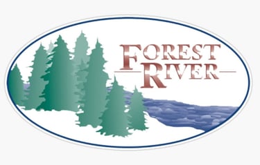 Forest River RV brand logo featuring green pine trees and a blue river in an oval frame.