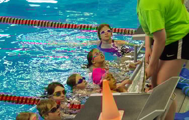 coach instructing kids swimming