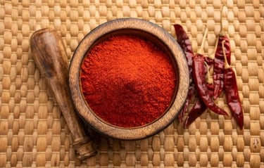 a bowl of chili powder with chili peppers and spices