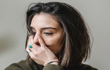 grieving woman with hand over mouth