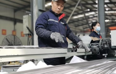 Industrial worker operating cutting or processing equipment in titanium manufacturing workshop for p