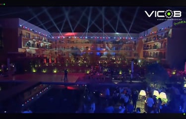 a man standing in front of a pool with a crowd of people