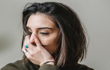 grieving woman with hand over mouth