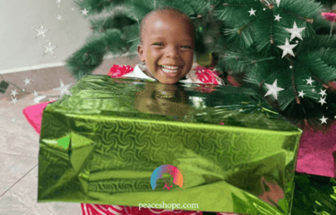 Kind aus Uganda hält großes Geschenk