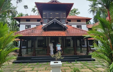 Front view of Poomuttath Illam, an aristocratic Kerala heritage home, framed by lush gardens