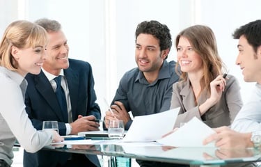 a group of business people sitting around a table martin pe coach