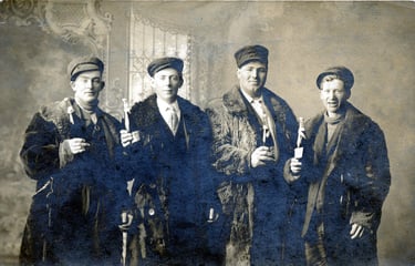 a black and white image of 5 men in fur coats and hats holding bottle so champagne