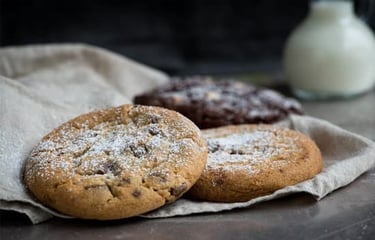 two cookies and a milkshake in a glass jar
