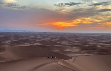 A view across the Moroccan Sahara from atop a dune at sunset