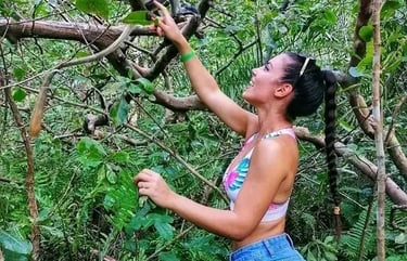 Tourist lady interacting and playing with a monkey in Jozani Forest Zanzibar during a wildlife tour