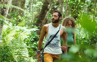 Couple walking along a nature trail in the lush Jozani Forest Zanzibar tropical rainforest