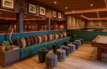 Solo Home Decor custom banquette with velvet pillows in a warm modern lounge with wood accents and soft lighting.