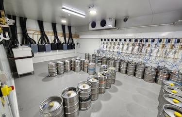 Cold storage room with stainless steel beer kegs and draft system glycol cooling lines.