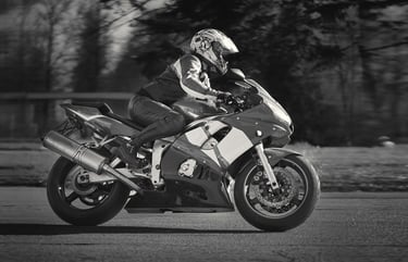 Black & White photograph of a rider riding from left to right on a sports bike