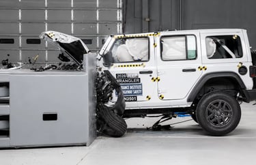 Jeep branco em teste de colisão frontal com airbags acionados em laboratório.
