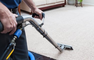 a man is cleaning a carpet with an extractor wand
