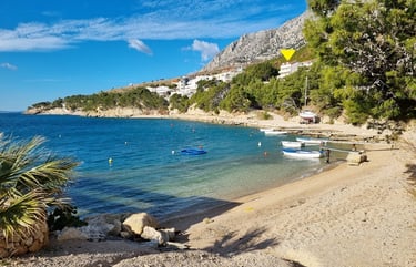 The photo shows the coastal part of Lokva Rogoznica with boats and houses above.