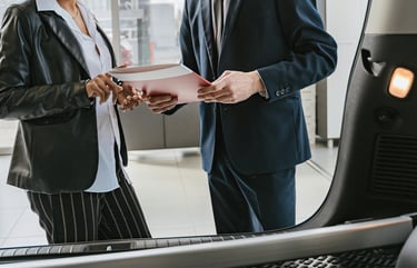 "Échange cordial entre un client et un professionnel dans une concession automobile.