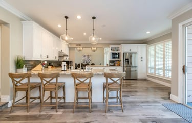 bright open kitchen and dining area with natural light, spotless counters, and welcoming table setti