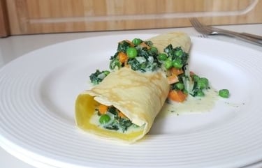 rolled German pancake on white plate with green veggies - copyright Tanja Dietzig