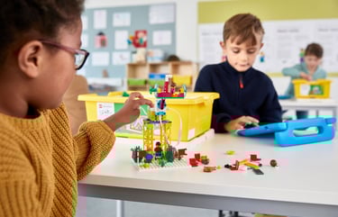 The SPIKE Essential robot kit with its white hub, motor, and collection of colorful LEGO bricks.