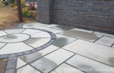 Blue Perforated Brick Wall Planter With Grey Sandstone Circle & Patio Paving & Wooden Pergola