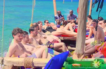 Tourists relaxing on the deck of Safari Blue Zanzibar boat tour, enjoying sun, turquoise waters, and scenic views