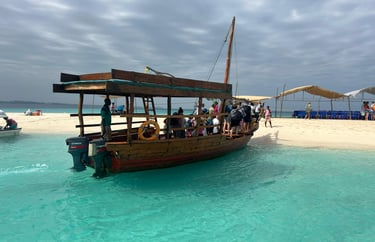 Local tour boat parked in shallow water at Nakupenda Sandbank, Zanzibar, as tourists get ready to explore.
