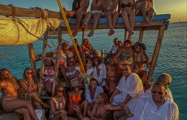 Traditional dhow sailing along Zanzibar’s coast during a stunning sunset, offering panoramic ocean views.
