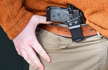gun being concealed inside the waist band of a pair of pants