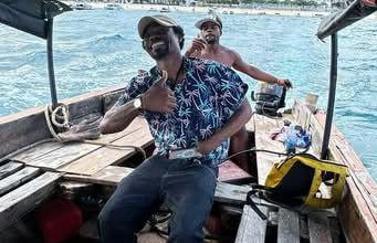 Smiling local Zanzibar tour guide on a boat trip with tourists to Prison Island (Changuu Island)