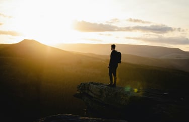 Man on a cliff representing a completed journey