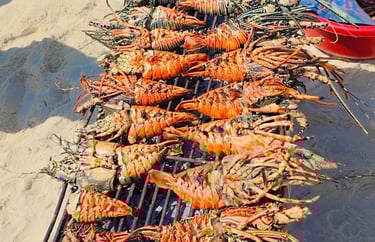 Fresh seafood lunch served on a sandbank during Safari Blue Zanzibar tour, including lobster, fish, and tropical fruits