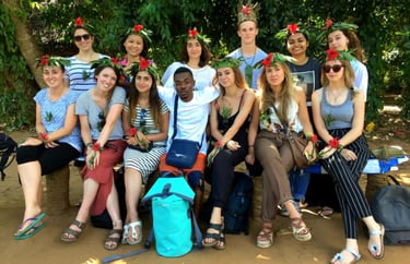 Group of tourists posing for a photo with a friendly local guide after completing the Zanzibar spice tour at a traditional 