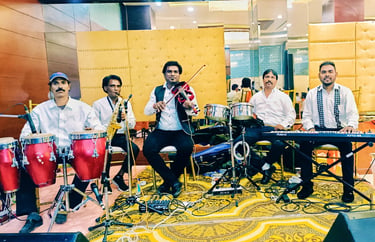 Live band performers playing violin, keyboard, saxophone, and conga drums on a stage. Musical Team 