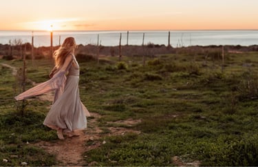 a woman in a long dress walking on a path
