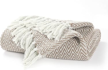Folded brown and white herringbone throw blanket with decorative fringe tassels.